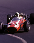 Vintage red Formula 1 car on a track with a dark background