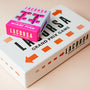 Miami Pink Lacorsa racecar set box on top of the Lacorsa game box on a cream background.