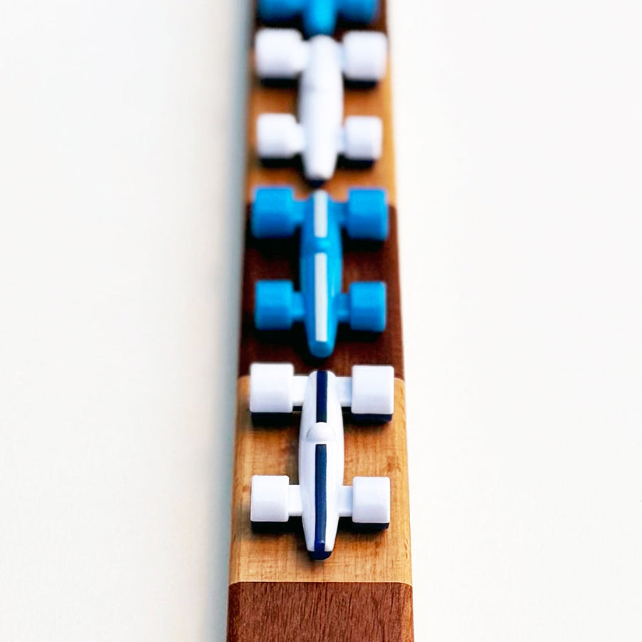 White and Medium Blue race cars on a checkered wooden race track
