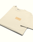 Folded Beige t-shirt with a Lacorsa Grand Prix Game logo on right chest on a white background