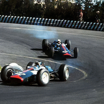 Two vintage Formula 1 cars racing on a track with a blurred background