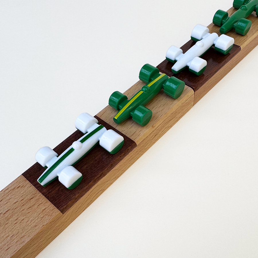 Toy race cars on a wooden checkerboard track with a white background